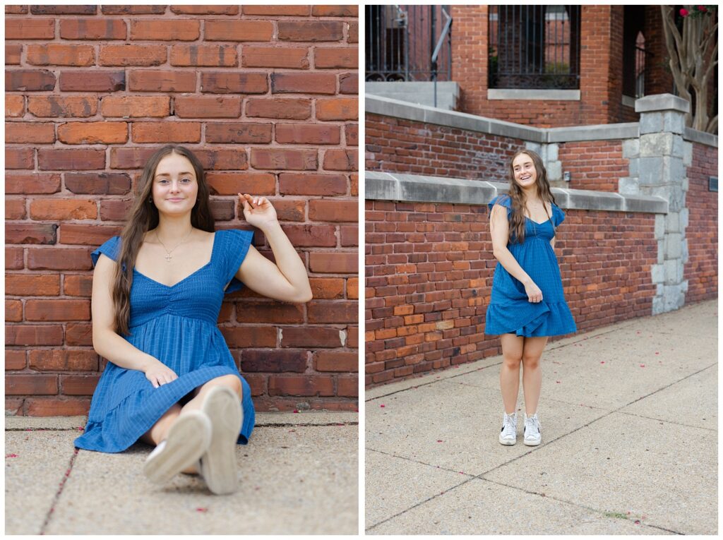 girl twirling her short blue dress on the sidewalk in front of a brick wall