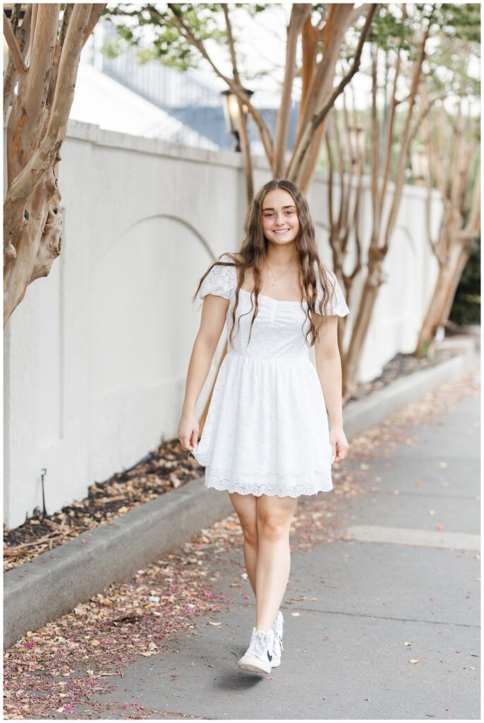 girl wearing a white dress walking along the sidewalk near the Read House Hotel