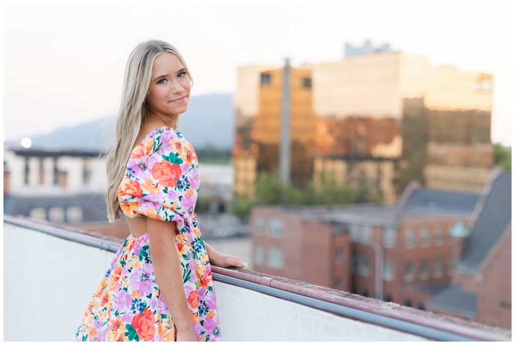 senior posing against the downtown Chattanooga skyline at golden hour on a rooftop