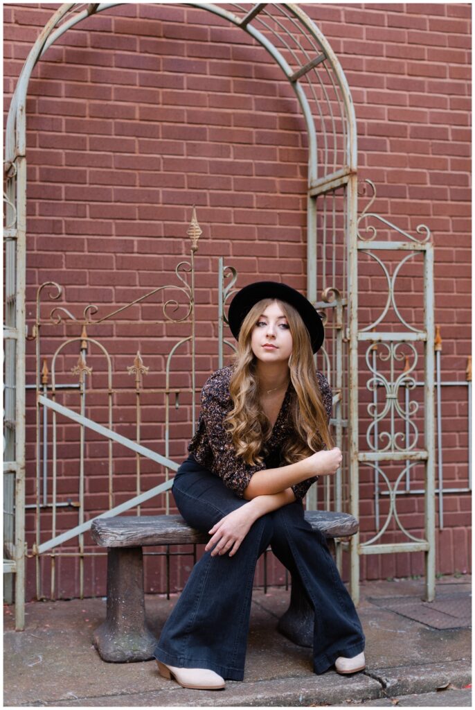 senior posing on a bench for portraits around the West Village in downtown Chattanooga