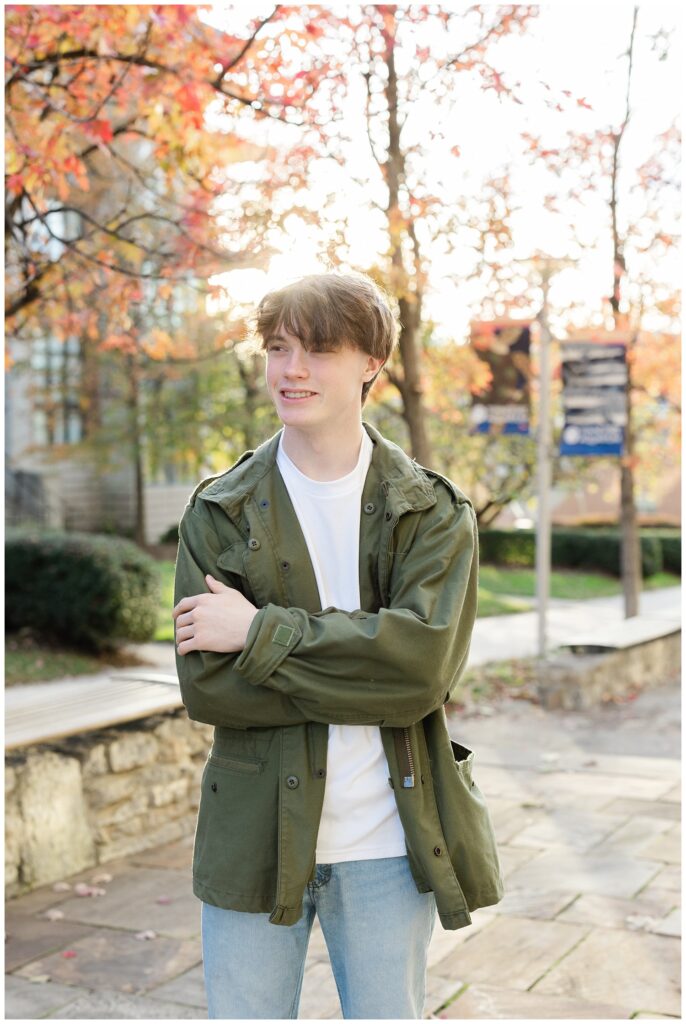 senior guy smiling and posing in front of orange and red trees for Chattanooga portrait session