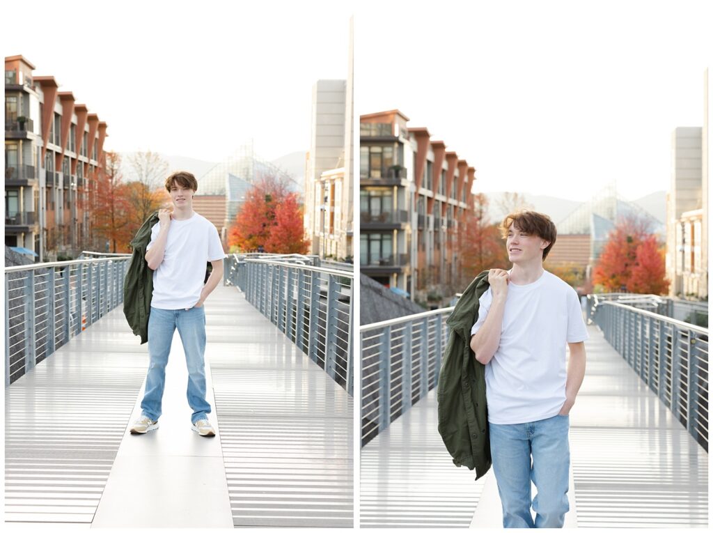 senior holding his green jacket over his shoulder on the steel walking bridge in Chattanooga