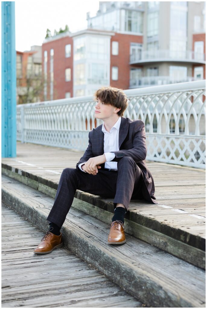 senior boy posing on the wooden sidewalk on the Walnut Street Bridge 