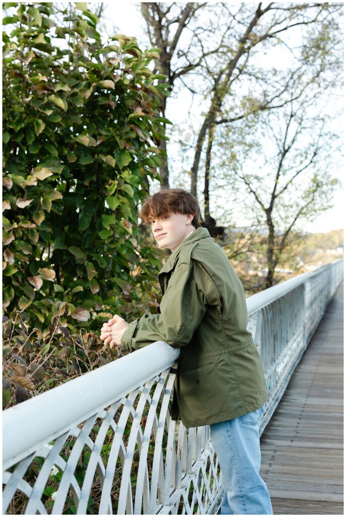 senior guy leaning with both arms on the white railing on the Walnut Street Bridge
