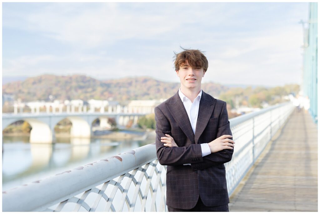 senior guy smiling during fall session with Chattanooga photographer on the bridge