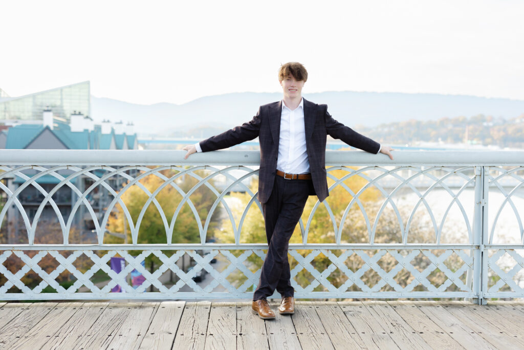 senior guy leaning with both arms on the white steel railing on the Walnut Street Bridge