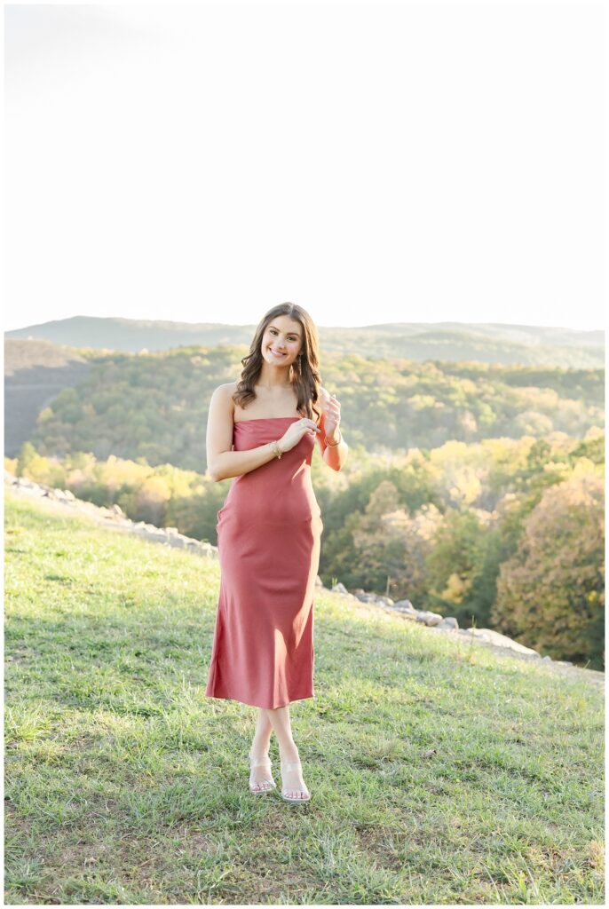 senior wearing a pink strapless dress and posing with mountains in the background in Chattanooga