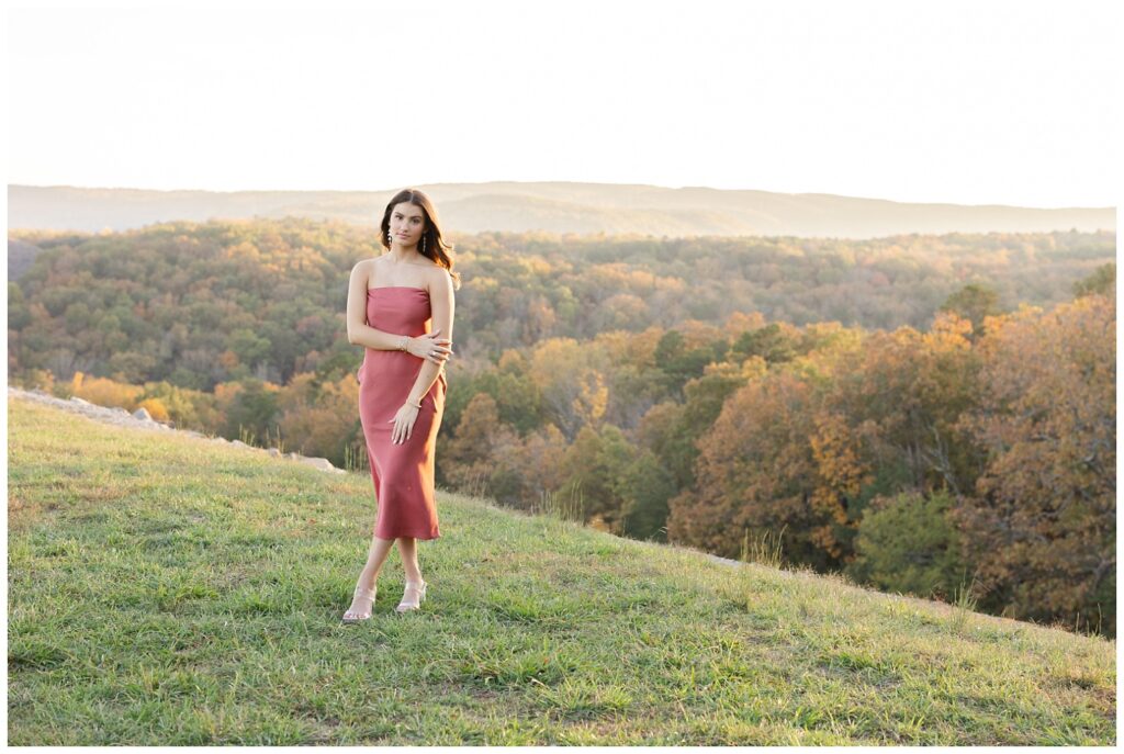 senior girl holding her forearm and posing in front of trees and mountains in Chattanooga