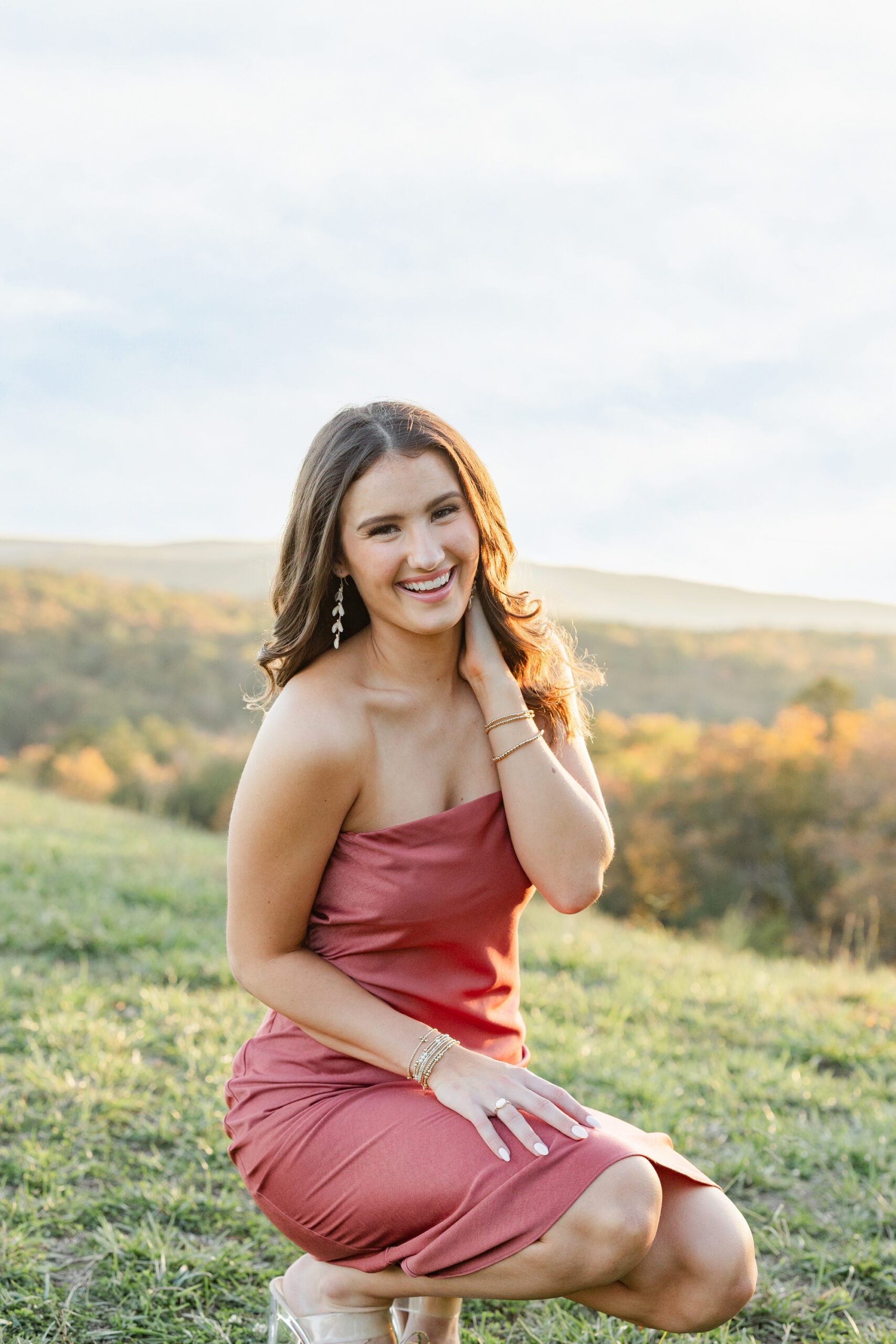 senior girl kneeling and smiling at Raccoon Mountain session