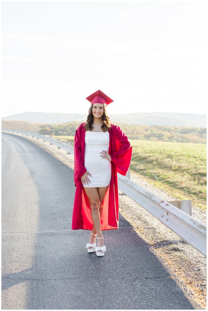 senior wearing a white dress and red cap and gown for Chattanooga portrait session