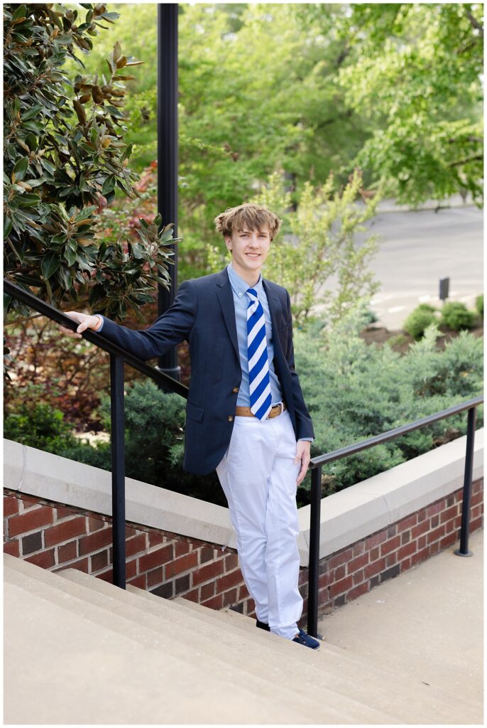 senior boy leaning against a railing posing on stairs for Chattanooga portrait session
