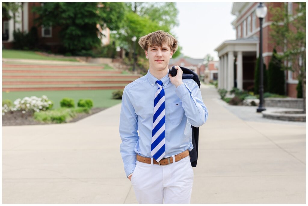 senior guy wearing a blue and white tie walking with his jacket over his shoulder at Chattanooga session