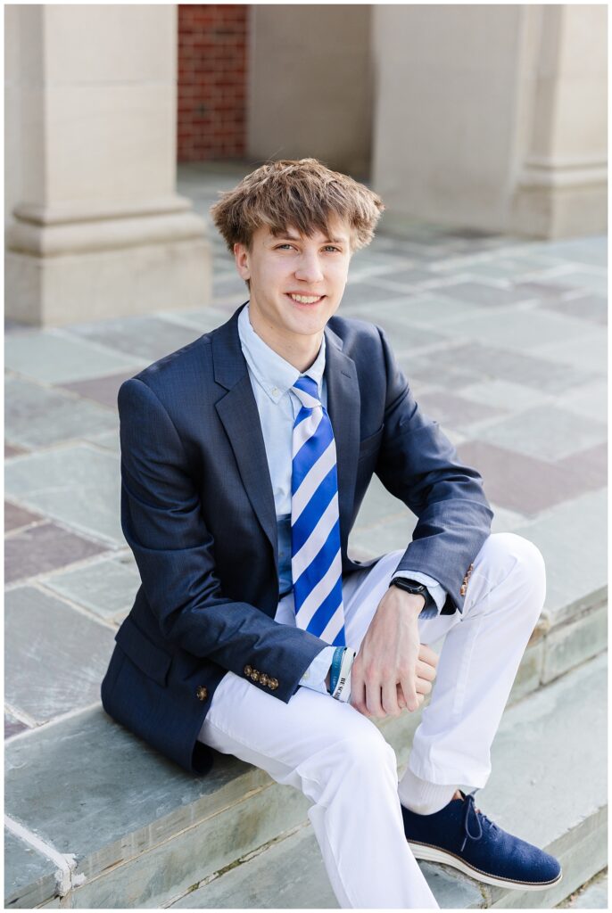 senior smiling while sitting on the stone steps at the McCallie School chapel