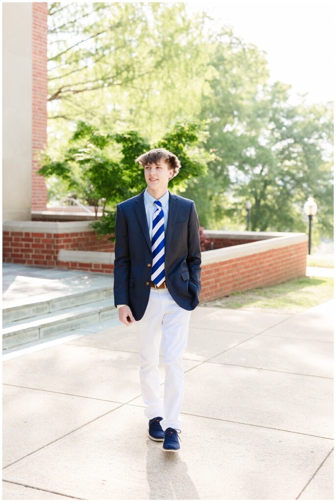 senior boy walking in front of the McCallie School chapel for spring portraits