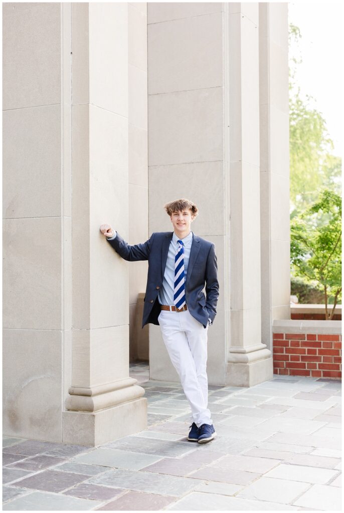 boy leaning against a large column at the chapel at McCallie senior session