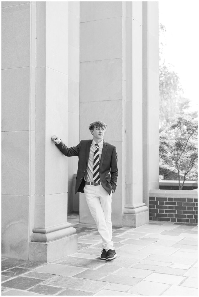 boy leaning against a large column and looking out from the chapel at McCallie senior session