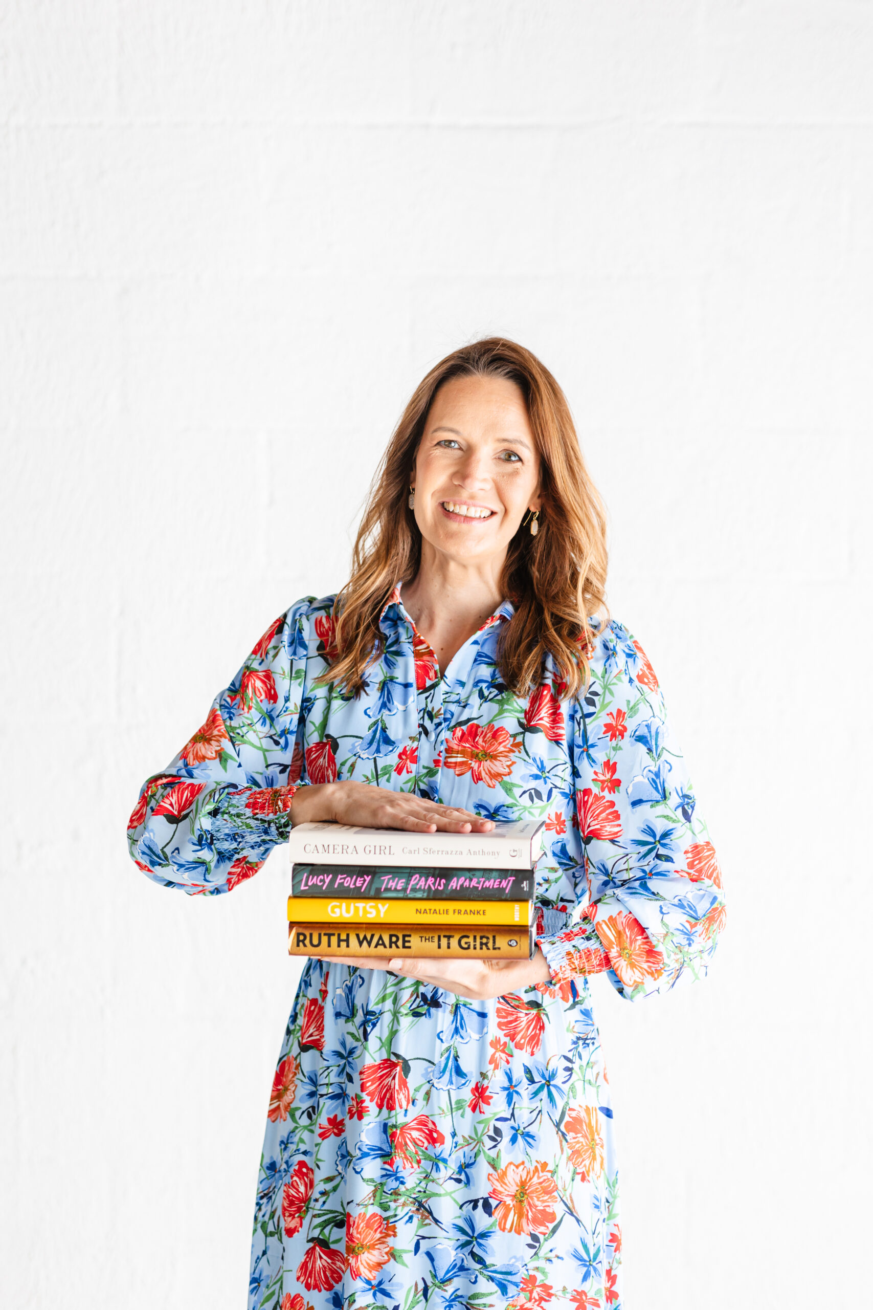 Chattanooga senior photographer holding a stack of books in a studio