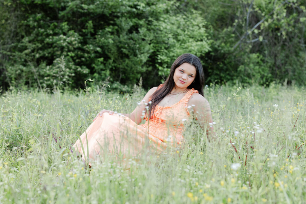 high school senior posing in the tall grass at Renaissance Park