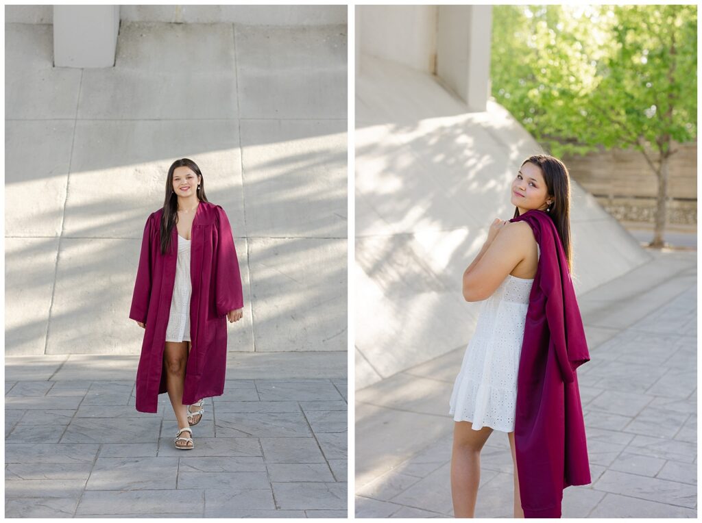 high school senior girl holding a maroon gown over her shoulder while wearing a white dress