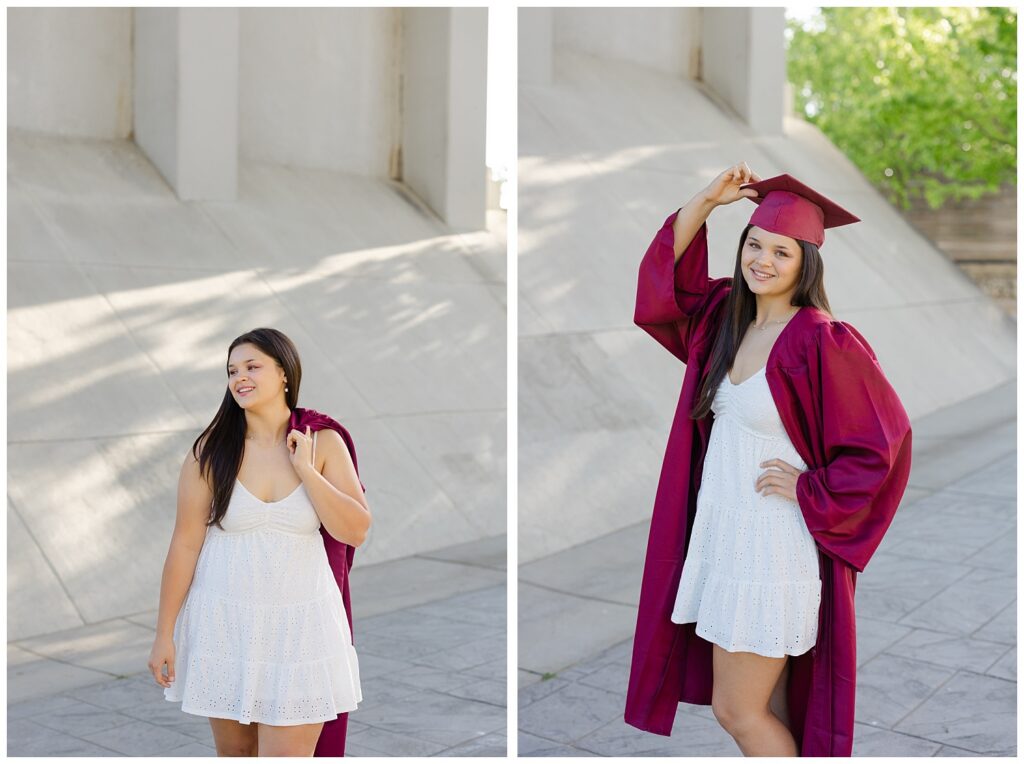 senior girl holding on to the tip of her graduation cap while smiling outside