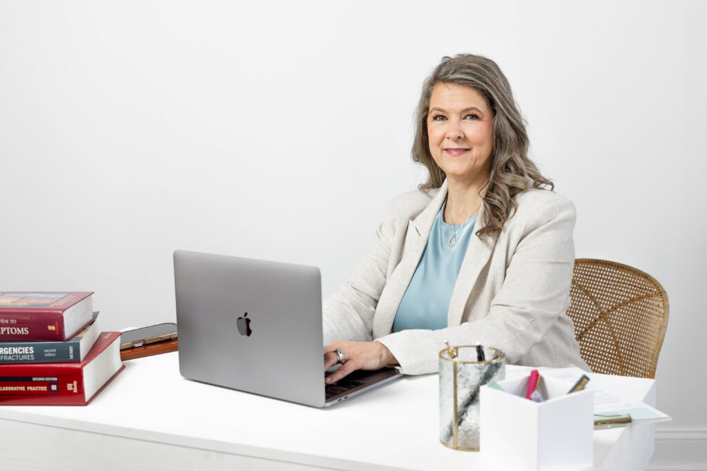 telemedicine nurse practitioner posing at a white desk for a branding session in Chattanooga