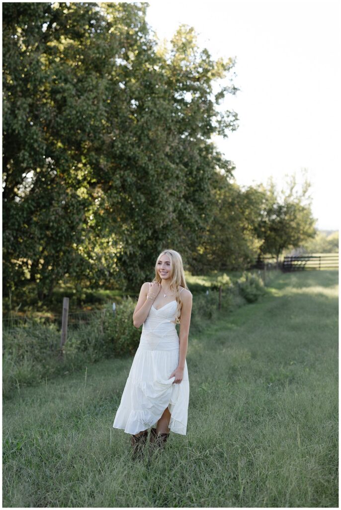 Chattanooga high school senior smiling and walking on her family farm wearing a white dress