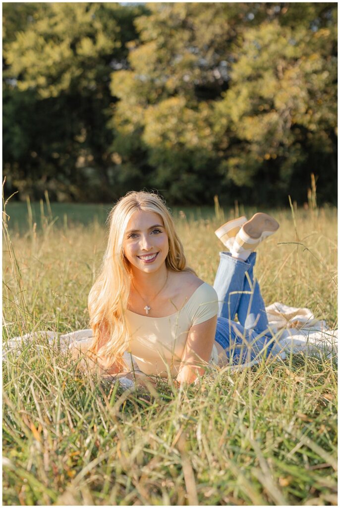 Chattanooga high school senior posing on her stomach wearing jeans and a yellow top