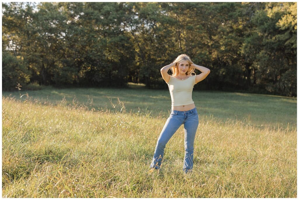 Chattanooga high school senior posing with her both hands in her hair and wearing jeans and a yellow top