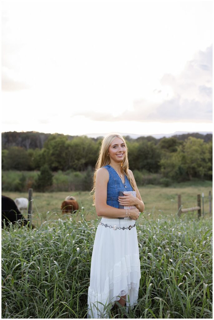 Chattanooga high school girl holding her Bible wearing a jean vest and white skirt on her family farm