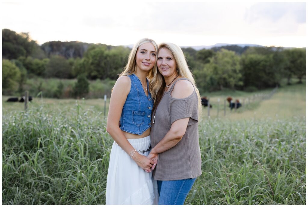 Chattanooga high school senior posing and holding hands with her mom on her family farm