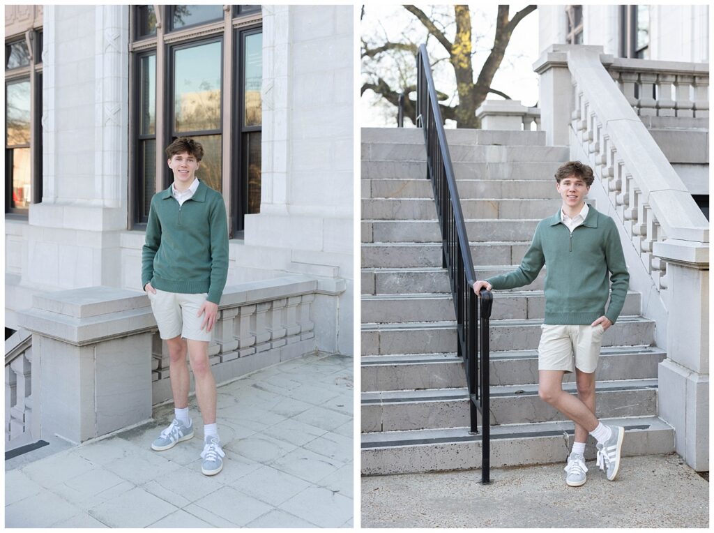 senior posing on the stairs and holding the stairwell wearing a green sweater