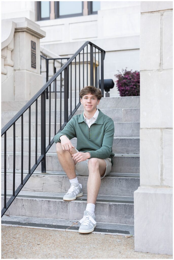 senior sitting on the Chattanooga courthouse stairs and resting his arms on his legs 