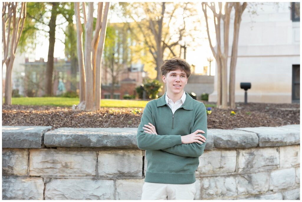 senior guy crossing his arms and looking away in front of a stone wall at Chattanooga courthouse
