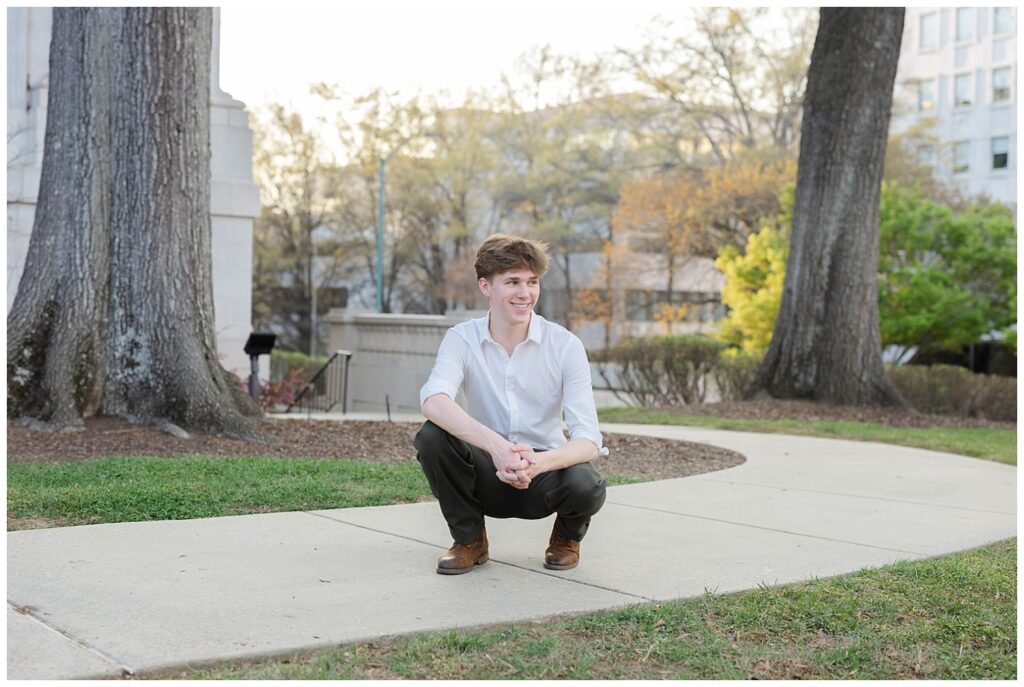 high school senior squatting on the sidewalk around the exterior of the Chattanooga courthouse