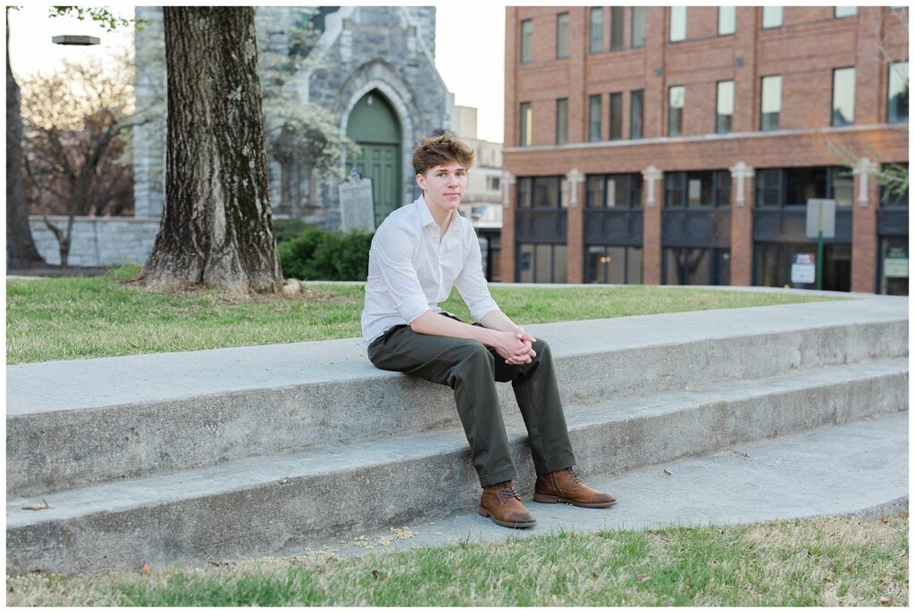 high school senior guy posing on the steps at Phillips Park in downtown Chattanooga