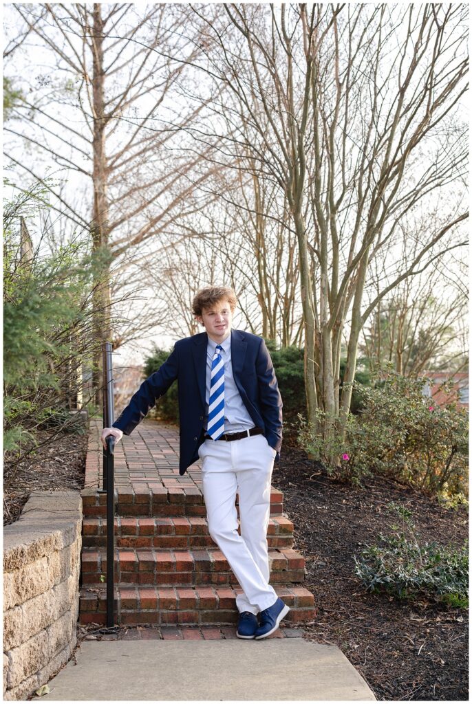 high school senior crossing his ankles and leaning against a handrail at McCallie School