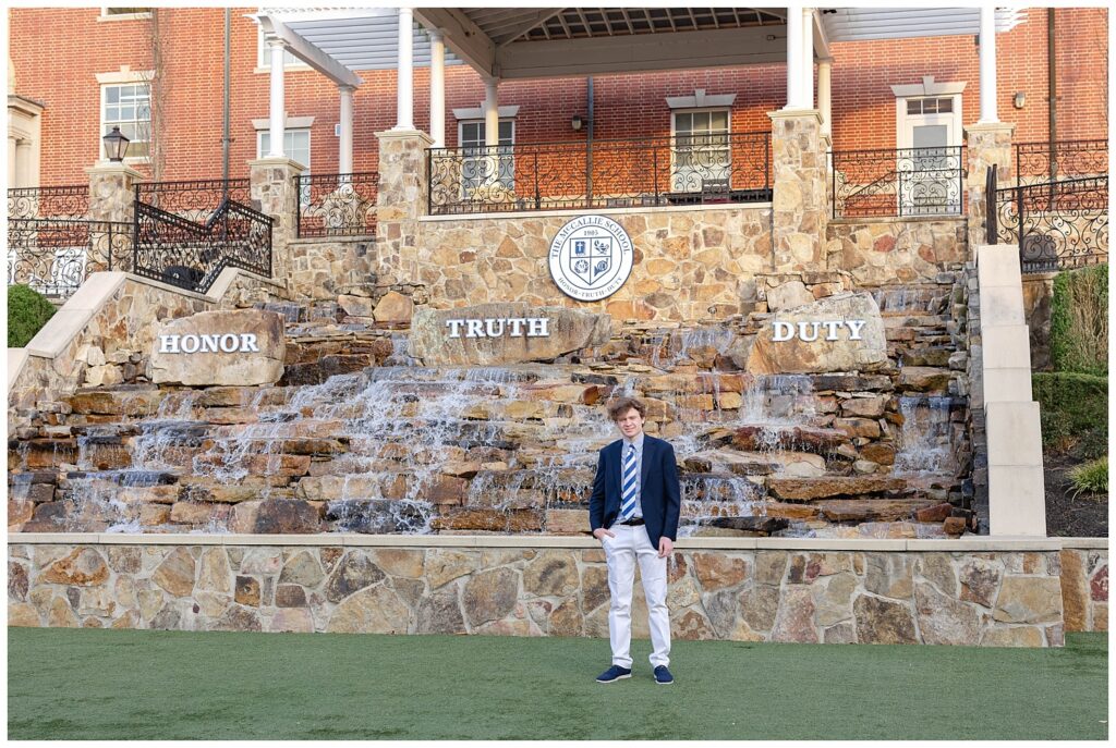 McCallie School high school senior posing in front of the rock wall and waterfall on campus